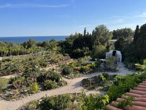 a garden with plants and the ocean in the background at 233 Casa Galo Verde Apartments in Porches