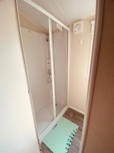 a mirror in a small bathroom with a shower at 8 Bed Sun Decked Caravan Unlimited High speed Wifi and fun at Seawick Holiday Park in Clacton-on-Sea