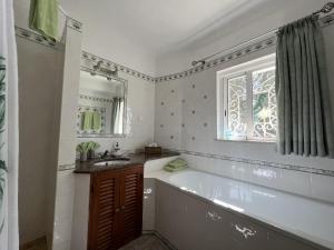 a bathroom with a tub and a sink and a window at 233 Casa Galo Verde Apartments in Porches