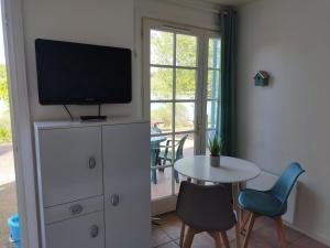 a living room with a tv on top of a dresser at Le petit jazz du lac in Marciac