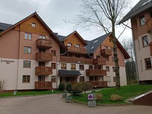 duży apartamentowiec z drewnianymi balkonami w obiekcie Apartament Miedzy Strumykami Karpacz w mieście Karpacz
