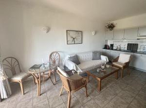 a living room with a couch and a table and chairs at 233 Casa Galo Verde Apartments in Porches