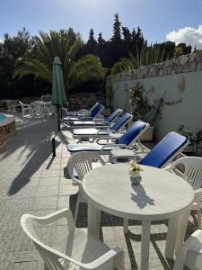 a row of tables and chairs and an umbrella at 233 Casa Galo Verde Apartments in Porches
