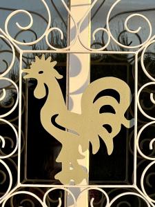 a metal fence with a stencil of a rooster on it at 233 Casa Galo Verde Apartments in Porches