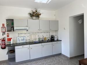 a kitchen with white cabinets and a sink at 233 Casa Galo Verde Apartments in Porches