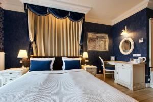 a bedroom with a large bed and a desk at SleepWalker Boutique Suites in Wrocław