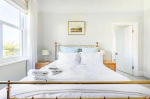 a white bedroom with a large bed with white sheets at Hedgebank in Exmouth