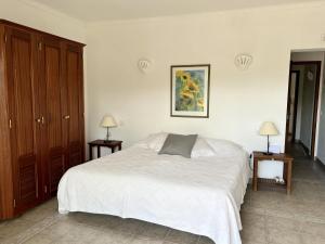 a bedroom with a white bed and two night stands at 233 Casa Galo Verde Apartments in Porches