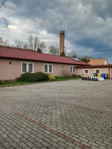 a house with a brick driveway in front of a building at Kata Panzió in Oroszlány