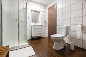 a white bathroom with a toilet and a shower at GARDEN Restaurant & Pension in Pardubice