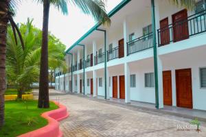 a row of buildings with palm trees and a sidewalk at Reecha Organic Resort Jaffna in Kilinochchi