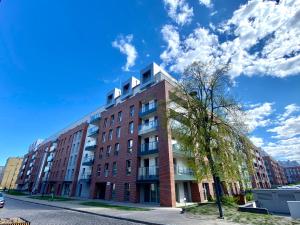 um edifício de tijolos vermelhos numa rua com um céu azul em Apartament Szafarnia DeLux em Gdańsk