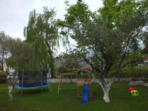 een speeltuin in een park met een boom bij Asprovalta Family Villas in Asprovalta