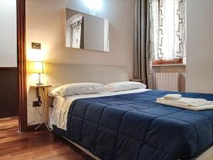 a bedroom with a large bed with a blue blanket at Ospitaci Appartamenti San Salvatore in Foligno