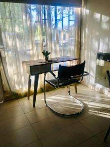 d'un bureau et d'une chaise en face d'une fenêtre. dans l'établissement Cálido Loft con pileta cerca del centro., à Villa Carlos Paz