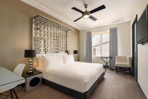 a bedroom with a bed with a ceiling fan and a desk at Waldorf Towers South Beach in Miami Beach