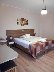 1 dormitorio con 1 cama grande y 1 mesa en Kata Panzió en Oroszlány