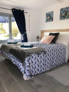 a bedroom with a bed with a blue and white comforter at Casa Alegria Spain Entire Home Private Pool in Antas