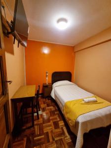 a bedroom with two beds and a table and a desk at Hotel Express in La Paz