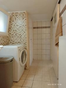een wasruimte met een wasmachine in de badkamer bij Antonia family house near Airport in Porto Rafti