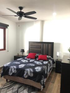 a bedroom with a bed and a ceiling fan at Condominio Alegre Amanecer in Santa Cruz Huatulco