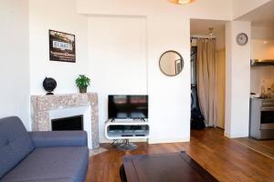 a living room with a blue couch and a fireplace at Appart Théâtre St Étienne Wi-Fi gratuit in Rennes