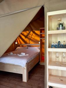 a bedroom with a canopy bed with two towels at Glamping Bagrem in Jablanica