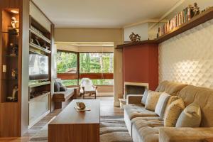 ein Wohnzimmer mit einem Sofa und einem Tisch in der Unterkunft CONFORTO NA SERRA in Campos do Jordão