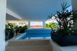 a swimming pool in a house with plants at XMX Pacific Pearl in Mazatlán
