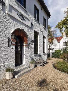 a white brick house with a black door at B&B Eikenlaan 12 in Genk