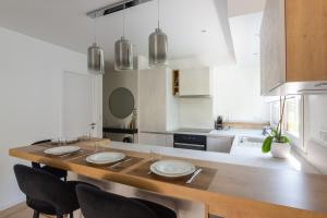 cocina con mesa de madera y 4 sillas en Calm and modern flat in Boulogne-Billancourt - Welkeys, en Boulogne-Billancourt