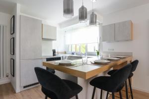 uma cozinha com uma mesa com cadeiras e um lavatório em Calm and modern flat in Boulogne-Billancourt - Welkeys em Boulogne-Billancourt