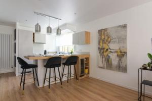 uma cozinha com um balcão e bancos num quarto em Calm and modern flat in Boulogne-Billancourt - Welkeys em Boulogne-Billancourt