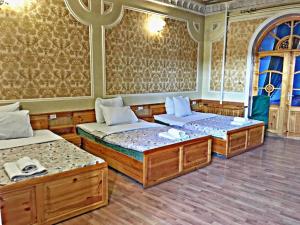 um quarto com três camas num quarto em Hotel KAMILA Prime em Samarkand
