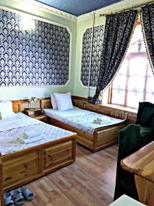 um quarto com 2 camas e uma janela em Hotel KAMILA Prime em Samarkand
