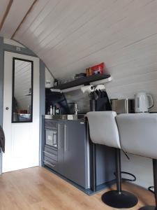 a kitchen with a counter and a table and chairs at Nevis Pod, West Highland Way Holidays in Kinlochleven