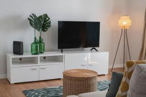 a living room with a white entertainment center with a flat screen tv at Solar da Fontinha by An Island Apart in Santa Cruz