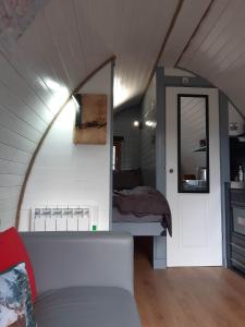 Nevis Pod, West Highland Way Holidays في كينلوشليفن: غرفة معيشة مع سرير وأريكة بيضاء