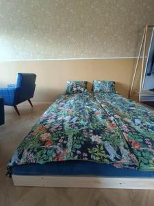 ein Schlafzimmer mit einem Bett und einem blauen Stuhl in der Unterkunft Hieno kaksio keskustassa rauhallisella alueella in Lovisa