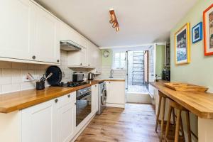 a kitchen with white cabinets and a wooden floor at Luxury apartment in the centre of Winchester in Winchester