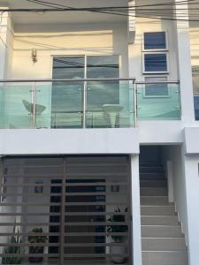a house with stairs and a balcony with chairs on it at Apartamento 202 Entero in Montería