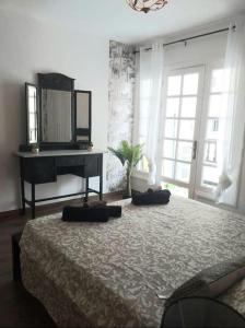1 dormitorio con 1 cama con piano y espejo en MAREZIA, en Corralejo