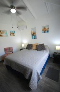 a bedroom with a bed and a ceiling fan at Gray Beach House in Potrero +22 photos