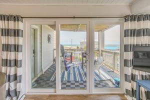 een kamer met een glazen schuifdeur en uitzicht op de oceaan bij Carolina Beach Condo with Community Pool in Carolina Beach