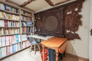 eine Bibliothek mit einem Holztisch und Bücherregalen in der Unterkunft Comfortable 1br in the 11th district of Paris - Welkeys in Paris