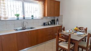 a kitchen with a sink and a table with chairs at Magda's garden home. in Galatás