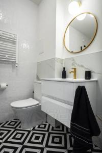 a bathroom with a sink and a toilet and a mirror at Apartment Marszalkowska Premium Warsaw City Center in Warsaw
