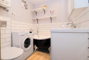 W łazience znajduje się pralka i umywalka. w obiekcie Gdynia Cozzi Apartment w mieście Gdynia