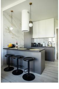 a kitchen with three bar stools at a counter at Apartment Marszalkowska Premium Warsaw City Center in Warsaw