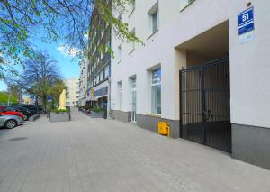 chodnik obok budynku z zaparkowanymi samochodami w obiekcie Gdynia Cozzi Apartment w mieście Gdynia